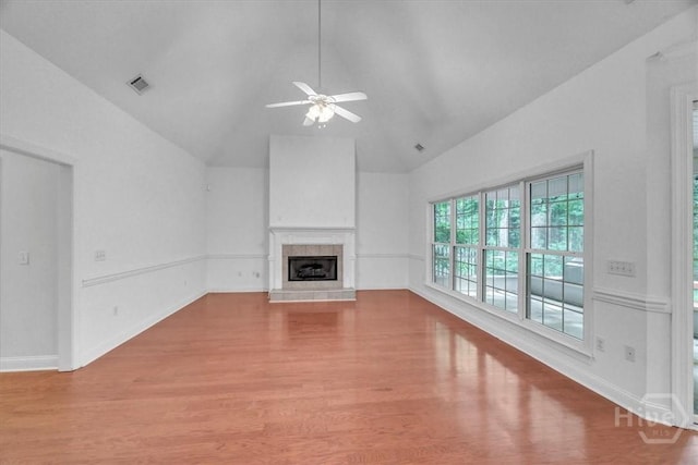 80 Windsong Dr, Richmond Hill, GA 31324 - unfurnished living room with wood finished floors, a ceiling fan, a tiled fireplace, and high vaulted ceiling