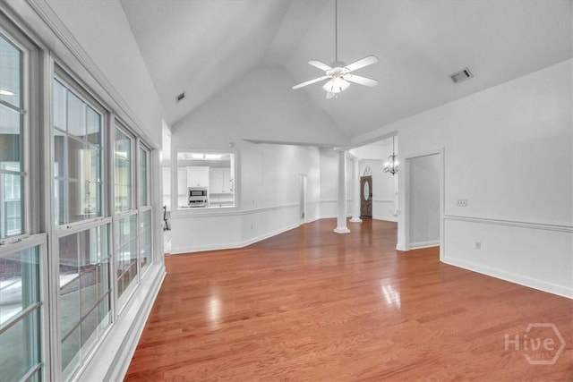 80 Windsong Dr, Richmond Hill, GA 31324 - empty room featuring decorative columns, high vaulted ceiling, wood finished floors, a ceiling fan, and a chandelier