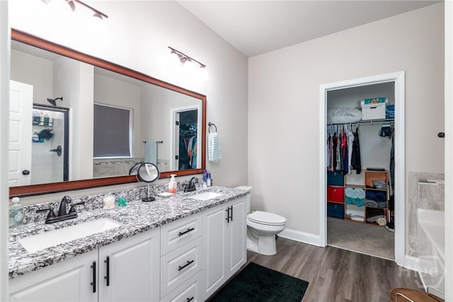 333 Providence Trce, Statesboro, GA 30461 - full bathroom featuring wood finished floors, a spacious closet, double vanity, a bathtub, and an enclosed shower