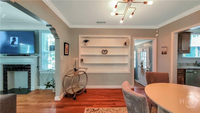 202 Columbus Dr, Savannah, GA 31405 - dining area with wood finished floors, plenty of natural light, crown molding, a tile fireplace, and a chandelier