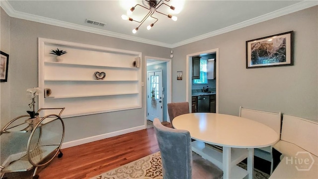 202 Columbus Dr, Savannah, GA 31405 - dining space with wood finished floors, ornamental molding, and a chandelier