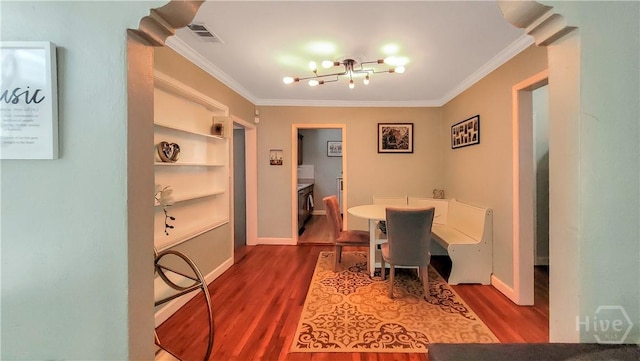 202 Columbus Dr, Savannah, GA 31405 - dining area featuring crown molding, wood finished floors, built in shelves, and a chandelier