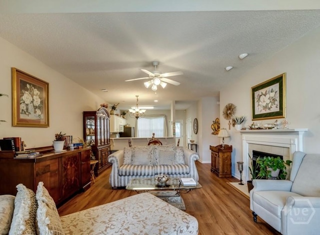 12 Crossing Dr, Richmond Hill, GA 31324 - bedroom featuring wood finished floors, a fireplace, fridge, a chandelier, and a textured ceiling