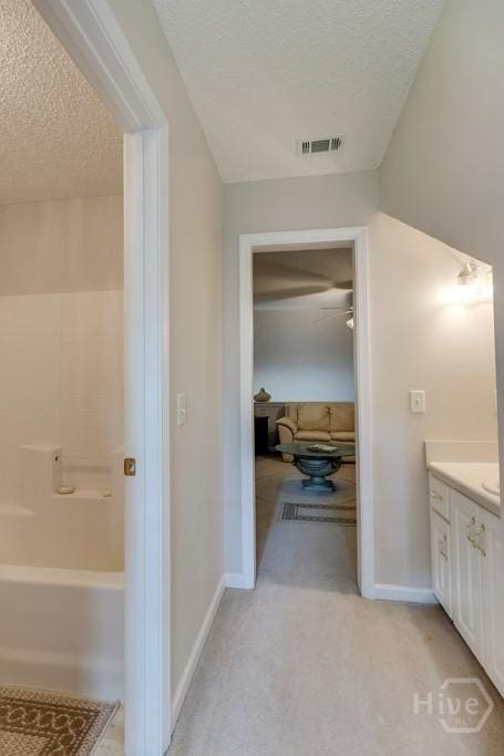 12 Crossing Dr, Richmond Hill, GA 31324 - bathroom featuring a textured ceiling, vanity, and tub / shower combination