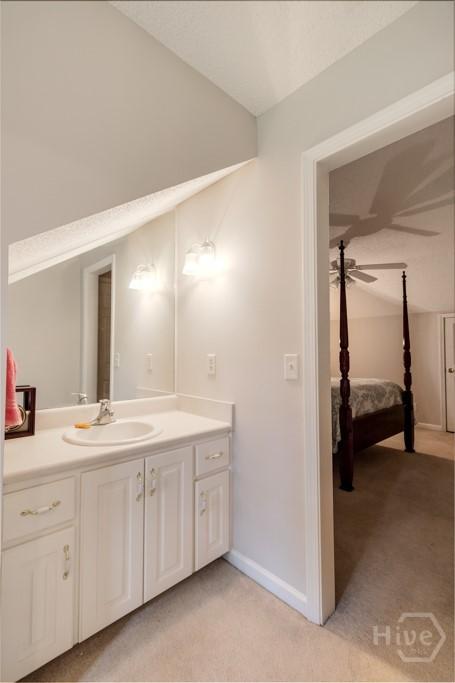 12 Crossing Dr, Richmond Hill, GA 31324 - ensuite bathroom featuring vanity, vaulted ceiling, and a ceiling fan