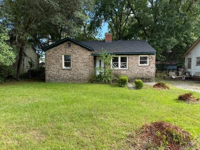 405 N Baldwin Cir, Savannah, GA 31405 - view of front of home featuring brick siding, a front yard, and a chimney