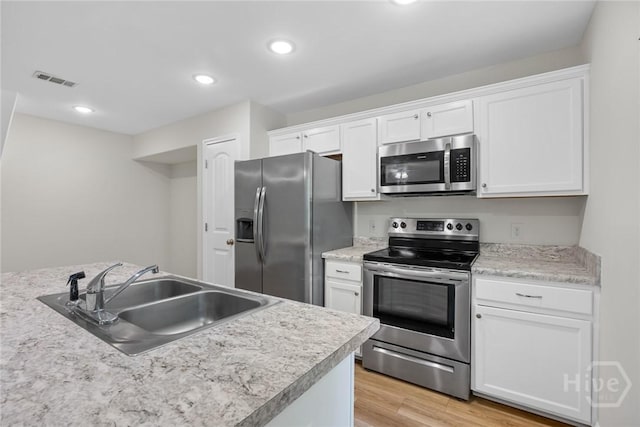 13 Abaco Ct, Savannah, GA 31419 - kitchen with stainless steel appliances, white cabinets, light wood-style floors, light countertops, and recessed lighting
