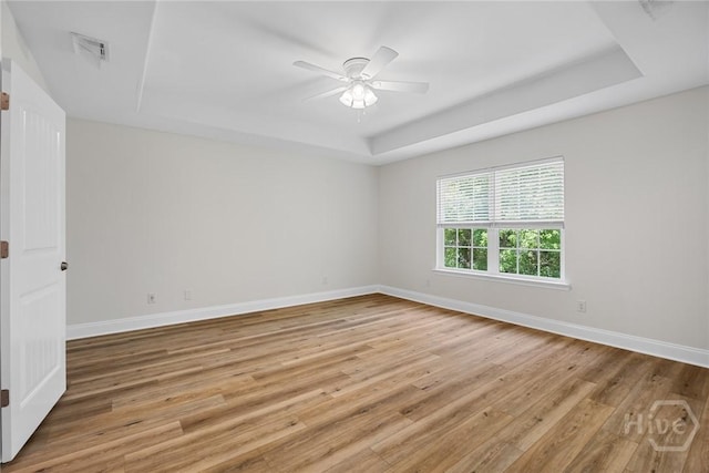 13 Abaco Ct, Savannah, GA 31419 - empty room featuring a tray ceiling, light wood-type flooring, and a ceiling fan