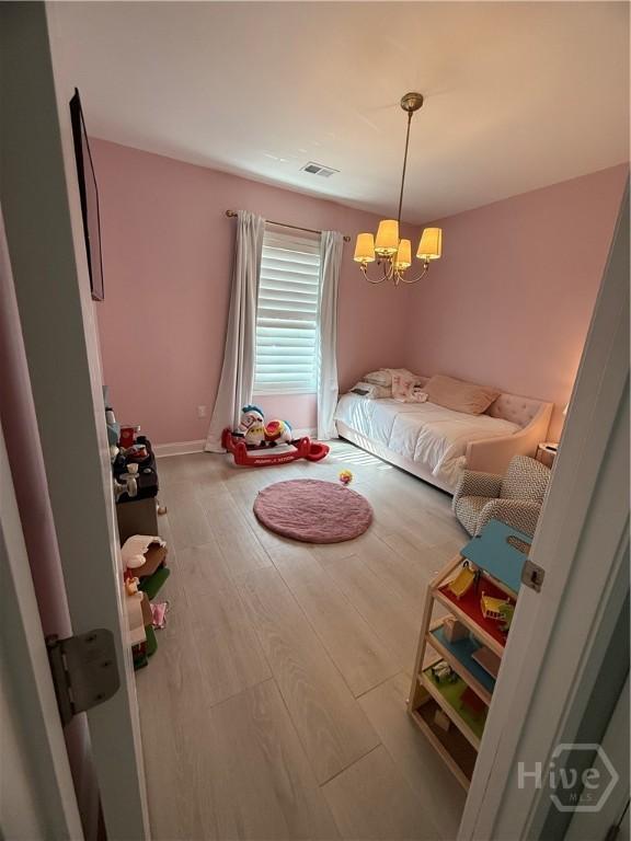 275 Heron Ct, Saint Marys, GA 31558 - bedroom with a chandelier and wood finished floors