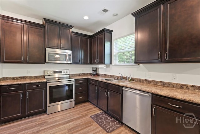 30 Melody Dr, Pooler, GA 31322 - kitchen with appliances with stainless steel finishes, light wood-style flooring, dark countertops, dark brown cabinetry, and recessed lighting