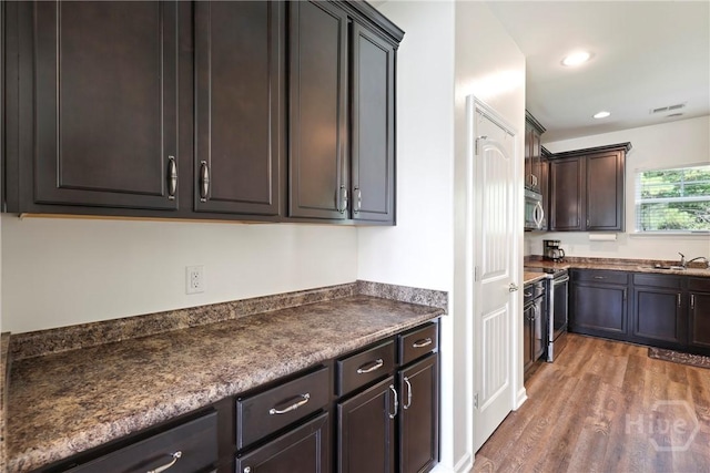 30 Melody Dr, Pooler, GA 31322 - kitchen featuring stainless steel appliances, wood finished floors, dark countertops, dark brown cabinetry, and recessed lighting