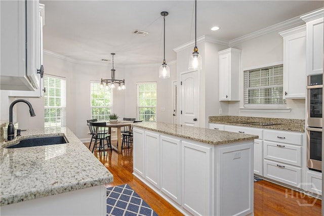 210 Windsong Dr, Richmond Hill, GA 31324 - kitchen with a kitchen island, white cabinetry, dark wood-style floors, double oven, and a chandelier