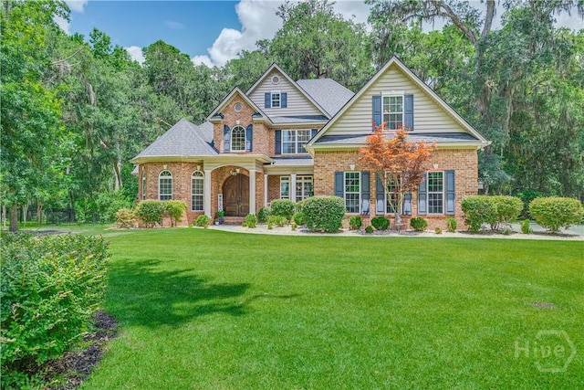 210 Windsong Dr, Richmond Hill, GA 31324 - traditional-style home with brick siding, a front lawn, and view of wooded area