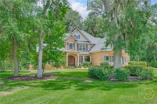 210 Windsong Dr, Richmond Hill, GA 31324 - view of front facade with brick siding and a front lawn