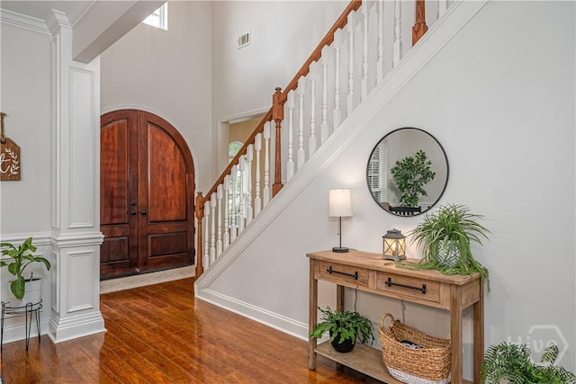 210 Windsong Dr, Richmond Hill, GA 31324 - foyer entrance with stairs, a towering ceiling, dark wood-type flooring, and crown molding