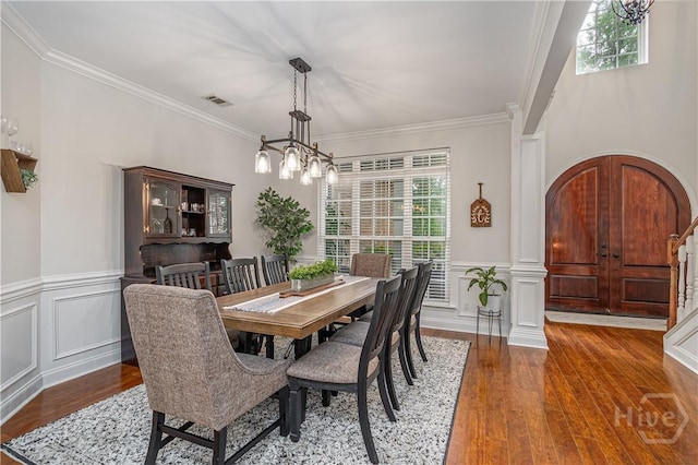 210 Windsong Dr, Richmond Hill, GA 31324 - dining area with ornamental molding, wood finished floors, a wainscoted wall, a decorative wall, and a chandelier