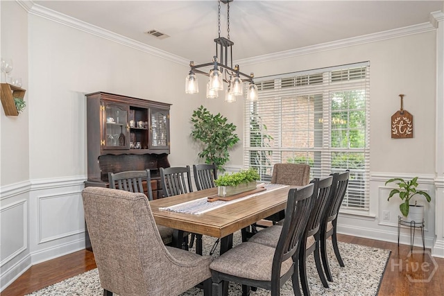 210 Windsong Dr, Richmond Hill, GA 31324 - dining area with wood finished floors, crown molding, a wainscoted wall, and a decorative wall