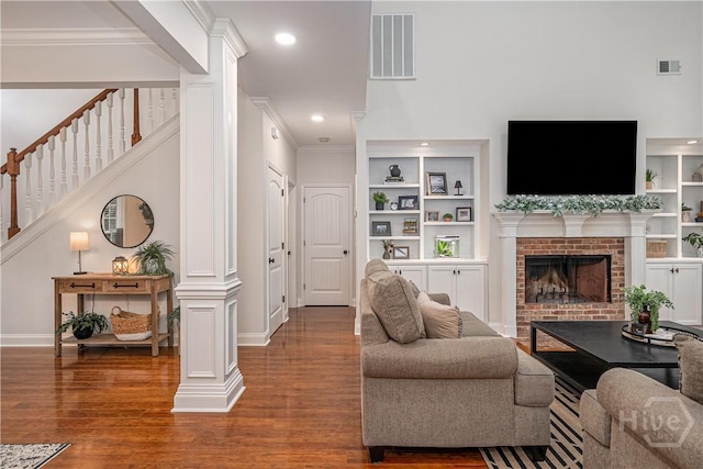210 Windsong Dr, Richmond Hill, GA 31324 - living area featuring ornate columns, built in shelves, wood finished floors, crown molding, and stairway