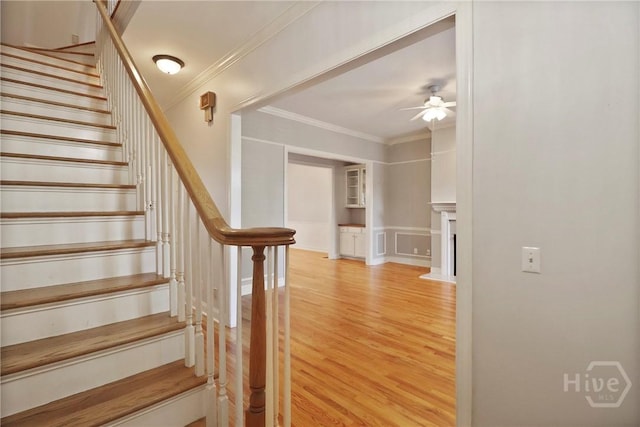536 E Harris St, Savannah, GA 31401 - staircase featuring ceiling fan, wood finished floors, crown molding, a decorative wall, and wainscoting