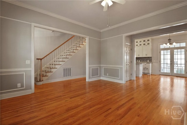 536 E Harris St, Savannah, GA 31401 - unfurnished living room with a chandelier, stairs, light wood finished floors, ceiling fan, and crown molding