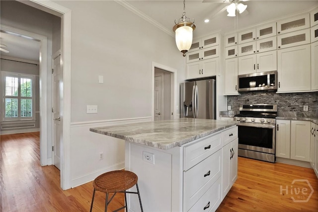 536 E Harris St, Savannah, GA 31401 - kitchen featuring appliances with stainless steel finishes, crown molding, decorative backsplash, ceiling fan, and white cabinets
