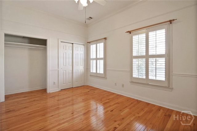 536 E Harris St, Savannah, GA 31401 - unfurnished bedroom with two closets, ornamental molding, light wood-style floors, and a ceiling fan