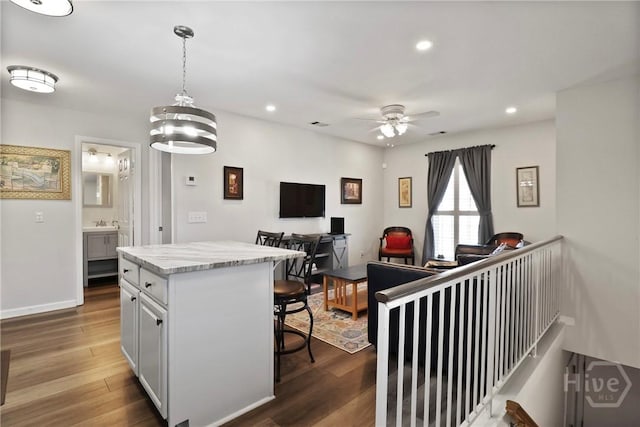 536 E Harris St, Savannah, GA 31401 - kitchen featuring a breakfast bar area, wood finished floors, a kitchen island, ceiling fan, and recessed lighting