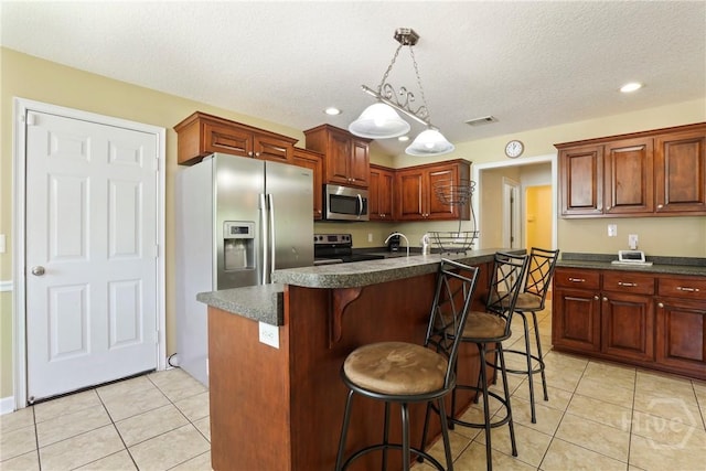 140 Kettle Creek Ln, Midway, GA 31320 - kitchen featuring appliances with stainless steel finishes, dark countertops, light tile patterned floors, a kitchen breakfast bar, and recessed lighting