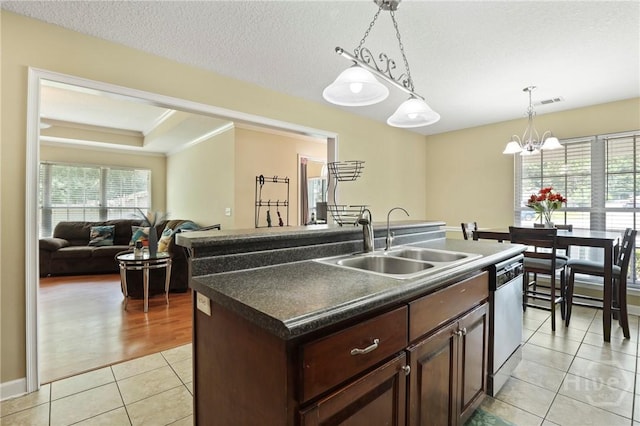 140 Kettle Creek Ln, Midway, GA 31320 - kitchen featuring a chandelier, dark countertops, light tile patterned floors, dishwasher, and an island with sink