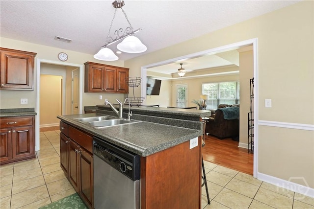 140 Kettle Creek Ln, Midway, GA 31320 - kitchen featuring stainless steel dishwasher, dark countertops, light tile patterned floors, and a breakfast bar area