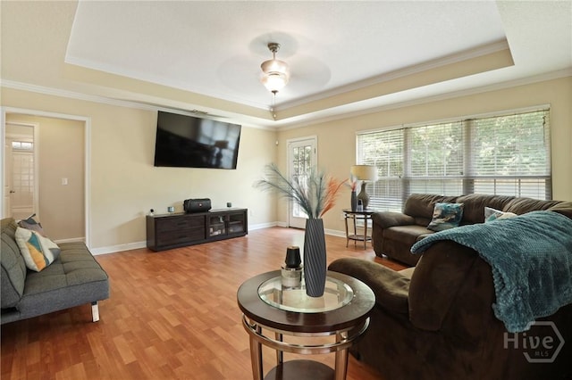 140 Kettle Creek Ln, Midway, GA 31320 - living room featuring a raised ceiling, light wood finished floors, ornamental molding, and a ceiling fan