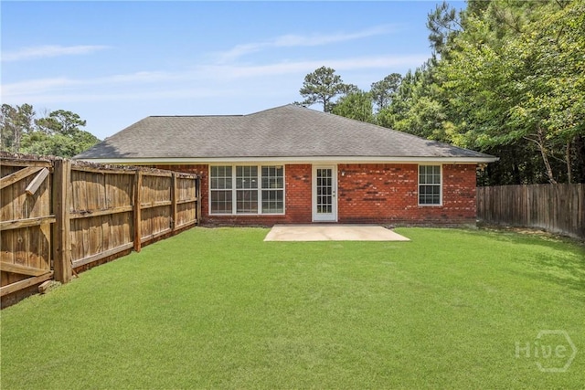 140 Kettle Creek Ln, Midway, GA 31320 - rear view of property featuring a fenced backyard, a patio area, brick siding, and roof with shingles