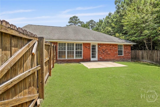 140 Kettle Creek Ln, Midway, GA 31320 - back of house with a fenced backyard, a patio area, brick siding, and roof with shingles