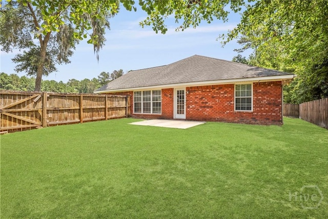 140 Kettle Creek Ln, Midway, GA 31320 - back of property featuring a patio, a fenced backyard, brick siding, and roof with shingles