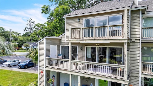 3005 River Dr Unit 302, Savannah, GA 31404 - rear view of property featuring a balcony, uncovered parking, and a shingled roof