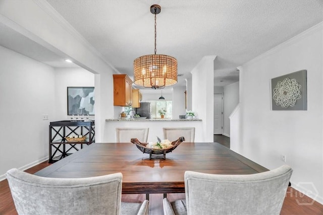 3005 River Dr Unit 302, Savannah, GA 31404 - dining space featuring a chandelier, ornamental molding, dark wood-type flooring, and a textured ceiling