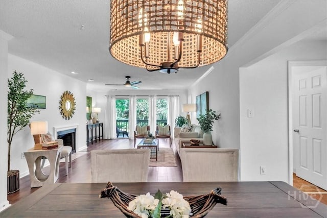 3005 River Dr Unit 302, Savannah, GA 31404 - dining room featuring ornamental molding, wood finished floors, a fireplace, a ceiling fan, and a chandelier