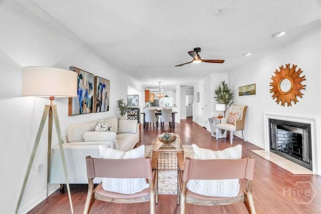 3005 River Dr Unit 302, Savannah, GA 31404 - living room with a ceiling fan, wood finished floors, a textured ceiling, and a fireplace