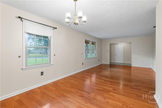 2 N Stillwood Ct, Savannah, GA 31419 - empty room with a chandelier, light wood finished floors, and a textured ceiling