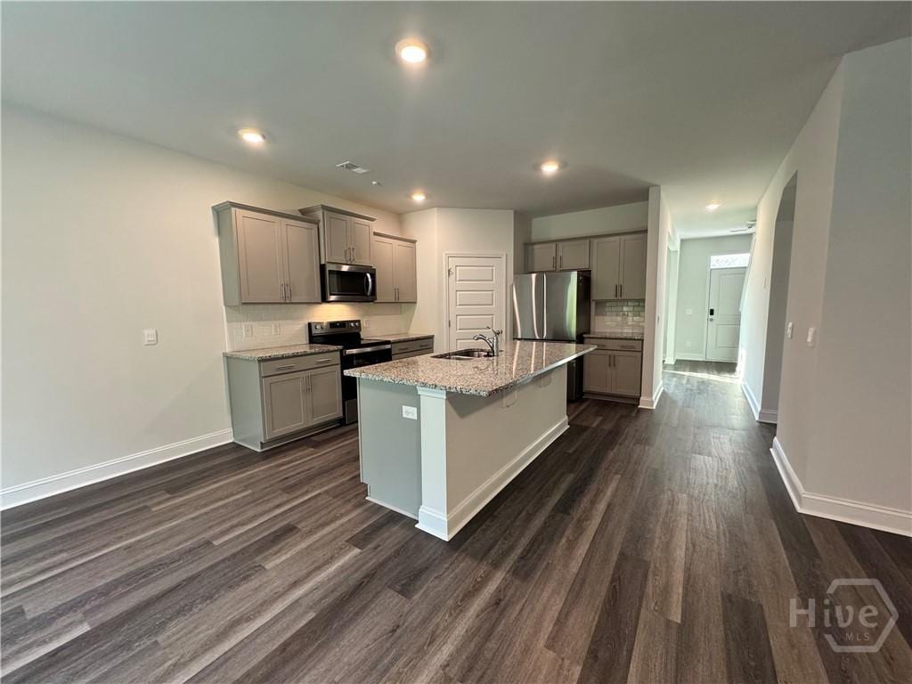 756 Logging Hill Dr, Richmond Hill, GA 31324 - kitchen with stainless steel appliances, gray cabinets, dark wood-type flooring, backsplash, and a kitchen island with sink