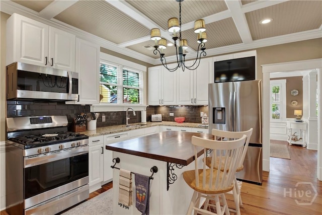 1507 E 49th St, Savannah, GA 31404 - kitchen with appliances with stainless steel finishes, coffered ceiling, a chandelier, tasteful backsplash, and light wood-type flooring