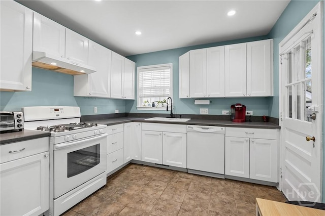 1424 E 53rd St, Savannah, GA 31404 - kitchen with white appliances, under cabinet range hood, dark countertops, white cabinets, and recessed lighting