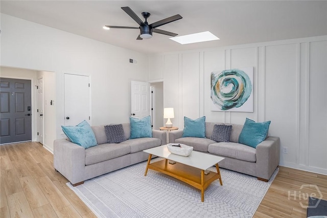 27 Bryan Wood Cir, Savannah, GA 31410 - living area with light wood-style floors, a ceiling fan, a skylight, and a decorative wall