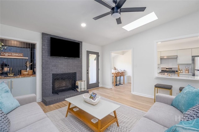 27 Bryan Wood Cir, Savannah, GA 31410 - living area with a ceiling fan, light wood finished floors, lofted ceiling, a fireplace, and a skylight