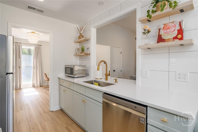 27 Bryan Wood Cir, Savannah, GA 31410 - kitchen with open shelves, stainless steel appliances, light countertops, light wood-style flooring, and gray cabinetry