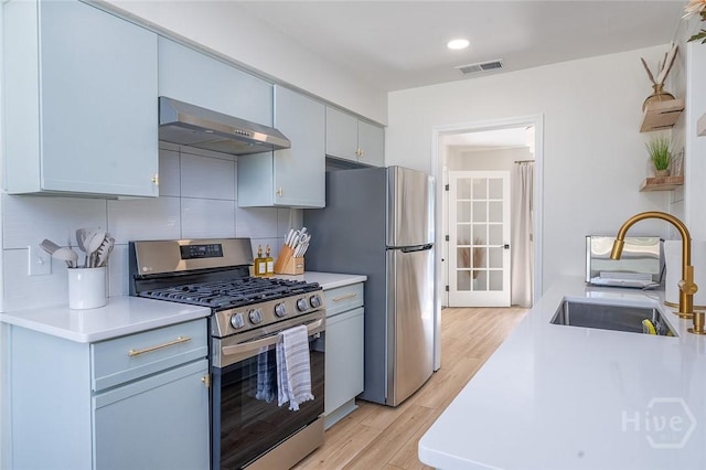 27 Bryan Wood Cir, Savannah, GA 31410 - kitchen with stainless steel appliances, range hood, light wood-style flooring, tasteful backsplash, and light countertops