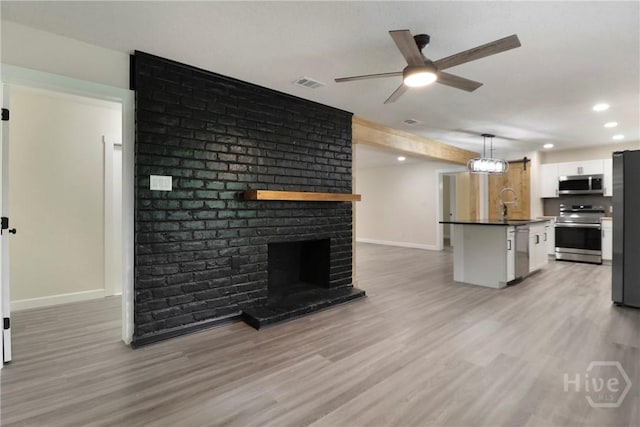 114 Paradise Dr, Savannah, GA 31406 - unfurnished living room with light wood-style floors, a ceiling fan, recessed lighting, a brick fireplace, and beamed ceiling