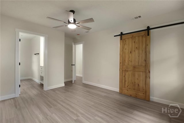 114 Paradise Dr, Savannah, GA 31406 - unfurnished bedroom with light wood finished floors, a barn door, and a ceiling fan