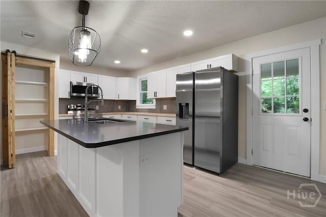 114 Paradise Dr, Savannah, GA 31406 - kitchen with appliances with stainless steel finishes, dark countertops, light wood finished floors, white cabinets, and recessed lighting