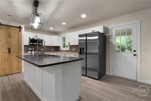 114 Paradise Dr, Savannah, GA 31406 - kitchen featuring appliances with stainless steel finishes, healthy amount of natural light, dark countertops, light wood finished floors, and recessed lighting